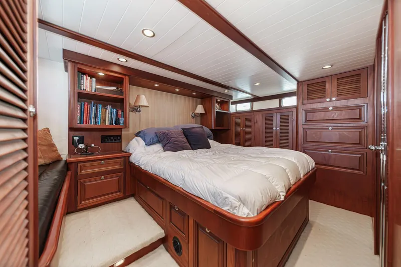 Slide: The Image of Luxurious 1963 DeFever Custom yacht bedroom with wood paneling and cozy bedding. - 11