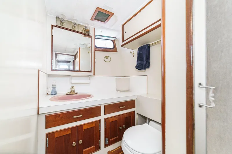 Slide: The Image of 1963 DeFever Custom Skallerud & Sons yacht bathroom with wood cabinets and pink sink. - 16