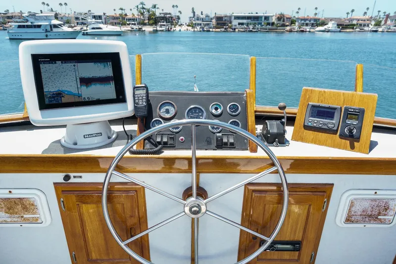 Slide: The Image of Helm of 1963 DeFever Custom Skallerud & Sons boat with navigation equipment and scenic harbor view. - 6