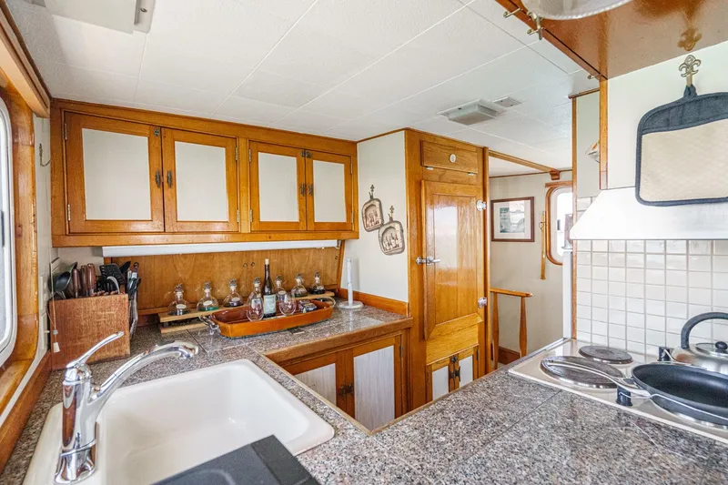 Slide: The Image of Vintage 1963 DeFever Custom Skallerud & Sons yacht kitchen with wooden cabinets and granite countertops. - 7