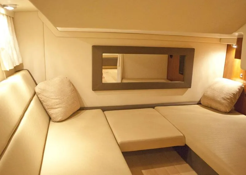 Slide: The Image of Manufacturer Provided Image: Interior cabin of a 2012 Regal 35 Sport Coupe with beige seating and cushions. - 12