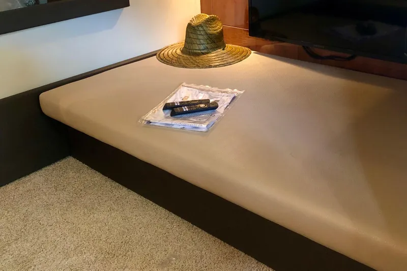 Slide: The Image of Interior of 2012 Regal 35 Sport Coupe with hat and remote on a beige seat. - 13