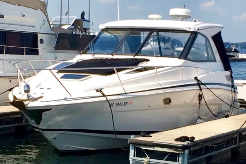 Slide: The Image of 2012 Regal 35 Sport Coupe docked at marina, sleek design, sunny day. - 2