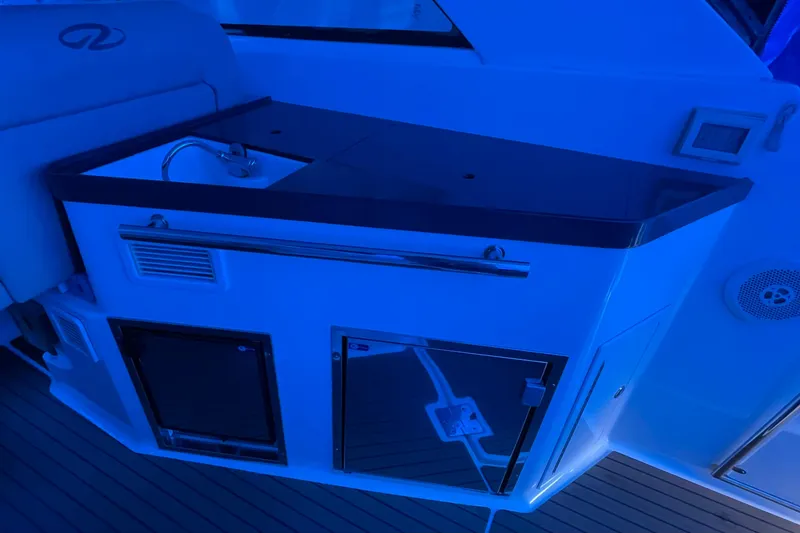 Slide: The Image of Interior of 2012 Regal 35 Sport Coupe with kitchenette under blue lighting. - 22