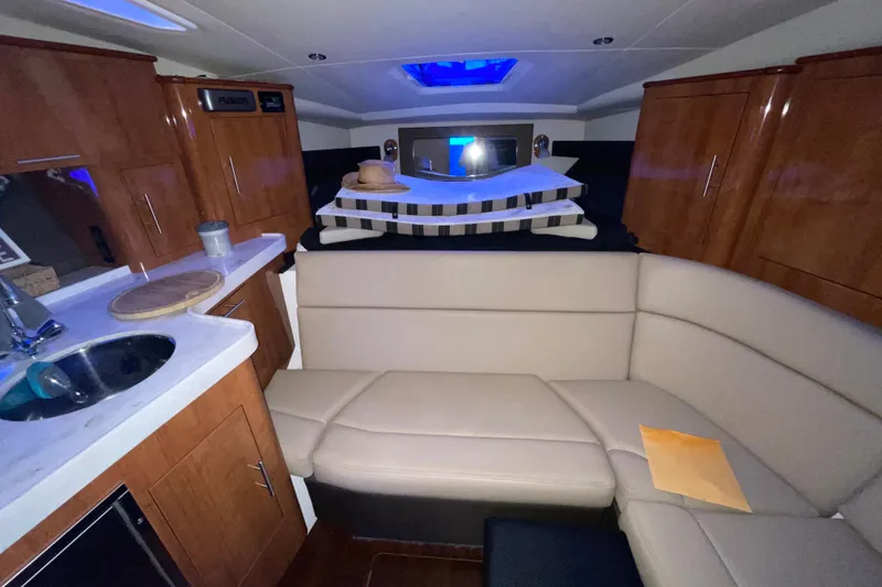 Slide: The Image of 2012 Regal 35 Sport Coupe interior kitchen with sink, microwave, and wooden cabinetry. - 36