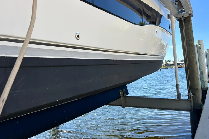 Slide: The Image of 2014 Sea Ray 370 Venture boat on lift by waterfront dock. - 10