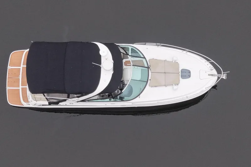 Slide: The Image of 2014 Sea Ray 370 Venture boat, aerial view, sleek design, black canopy, wooden deck. - 12