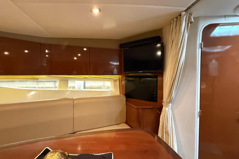 Slide: The Image of Interior of 2014 Sea Ray 370 Venture yacht with seating, TV, and wooden cabinetry. - 20