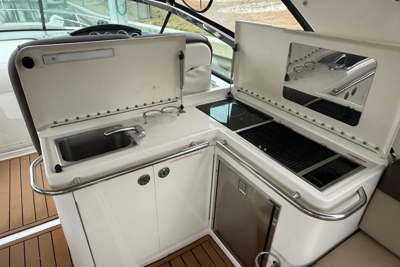 Slide: The Image of 2014 Sea Ray 370 Venture boat kitchen with sink, stove, and grill. - 24