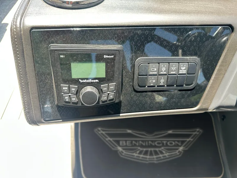 Slide: The Image of The image shows the dashboard of a Bennington 24 MSL boat with a Rockford Fosgate radio and a switch panel. - 19