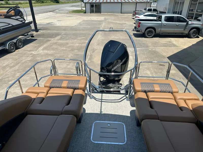 Slide: The Image of The image shows the rear of a Bennington 24 MSL pontoon boat with beige loungers and an outboard motor. - 12