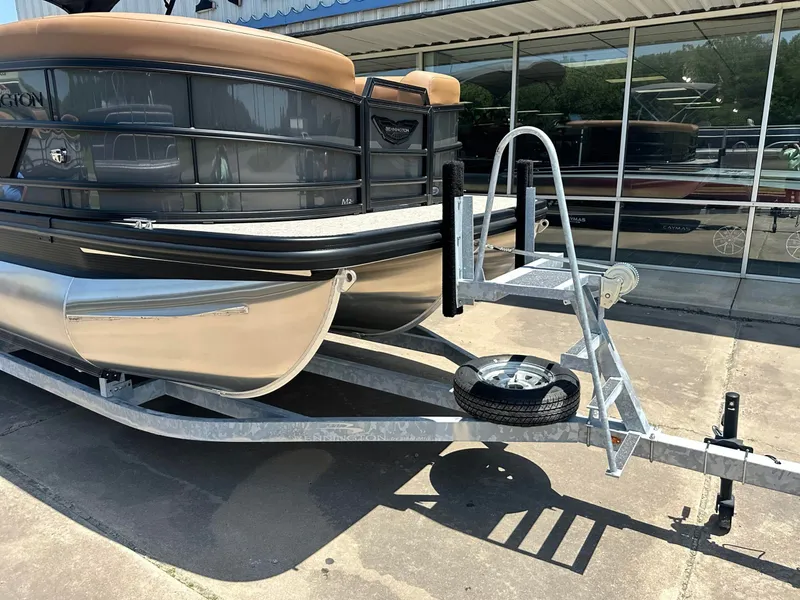Slide: The Image of A Bennington 24 MSL pontoon boat on a trailer in front of a glass-fronted building. - 15