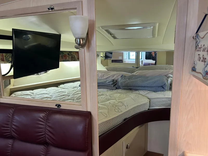 Slide: The Image of 1997 Tiara Yachts 3500 Express cabin interior with bed, TV, and seating area. - 16