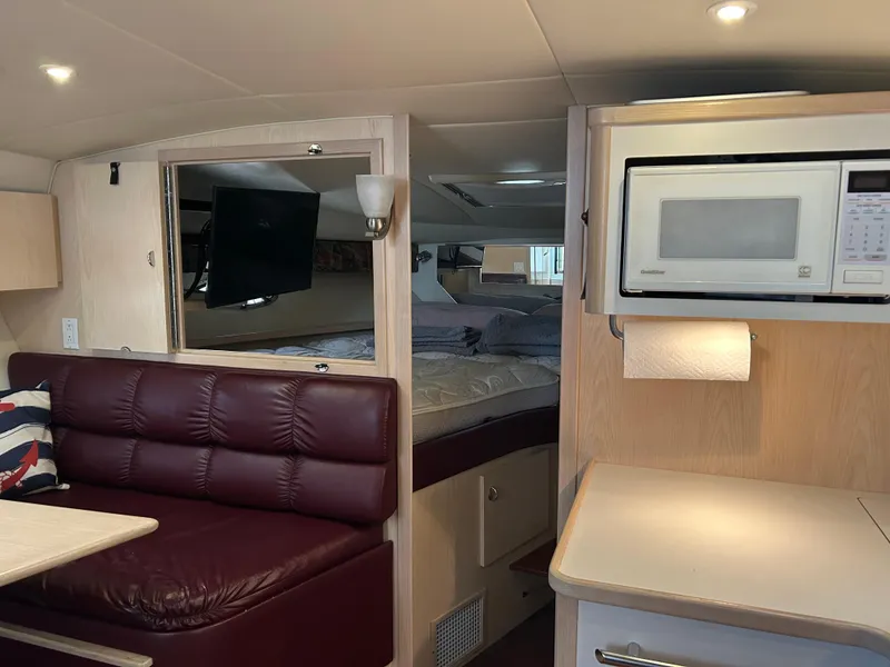 Slide: The Image of Interior of 1997 Tiara Yachts 3500 Express with seating, bed, and microwave. - 18