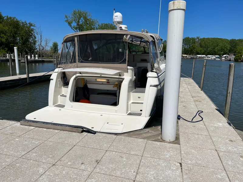 Slide: The Image of 1997 Tiara Yachts 3500 Express docked at a marina on a sunny day. - 2