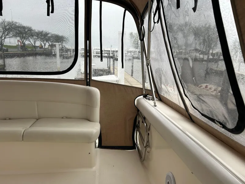 Slide: The Image of 1997 Tiara Yachts 3500 Express interior with white seating and marina view. - 41