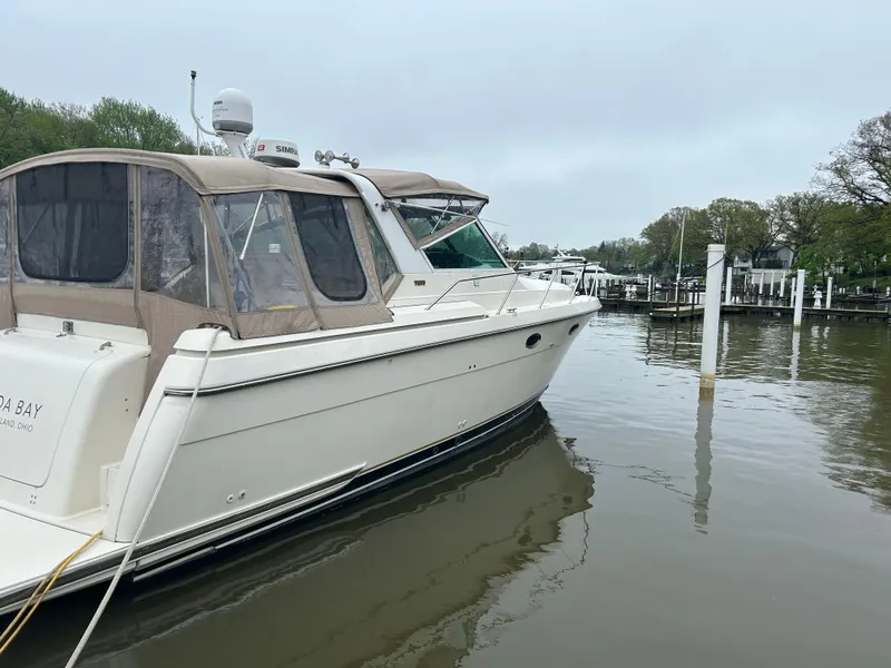 Slide: The Image of 1997 Tiara Yachts 3500 Express docked in a serene marina setting. - 46