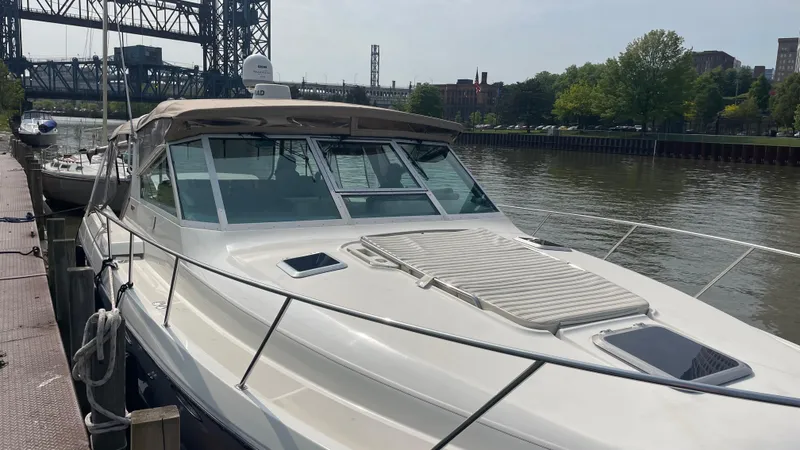 Slide: The Image of 1997 Tiara Yachts 3500 Express docked by a river with a bridge in the background. - 5