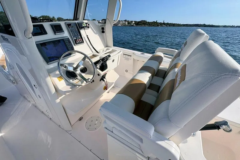 Slide: The Image of 2012 Everglades 295 Center Console boat interior with steering wheel and navigation controls. - 10