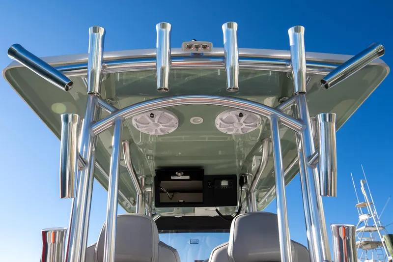Slide: The Image of 2026 Bay Rider 269 Bay boat with stainless steel rod holders and speakers under a clear blue sky. - 15