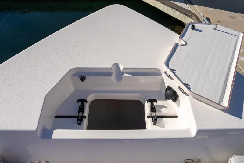 Slide: The Image of 2026 Bay Rider 269 Bay boat compartment with open hatch, dockside view. - 25