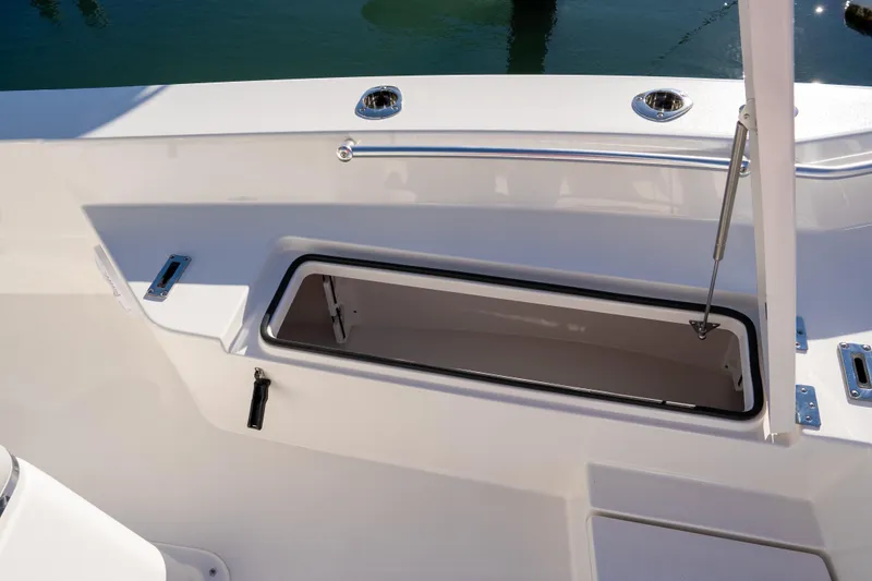 Slide: The Image of 2026 Bay Rider 269 Bay boat storage compartment with open hatch, docked on water. - 30