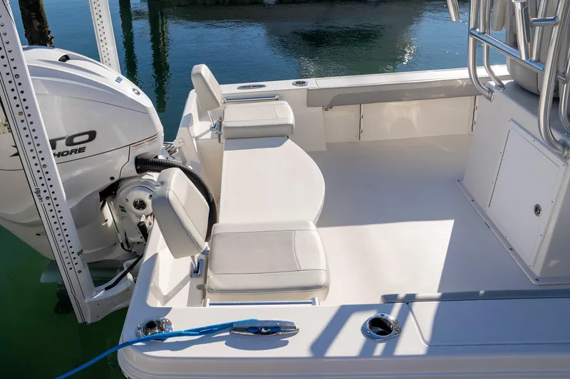 Slide: The Image of 2026 Bay Rider 269 Bay boat interior with seating and motor, docked on calm water. - 40