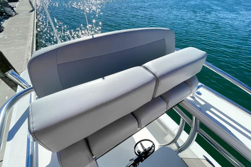 Slide: The Image of 2026 Bay Rider 269 Bay boat seat with sleek design, docked by sparkling water. - 51