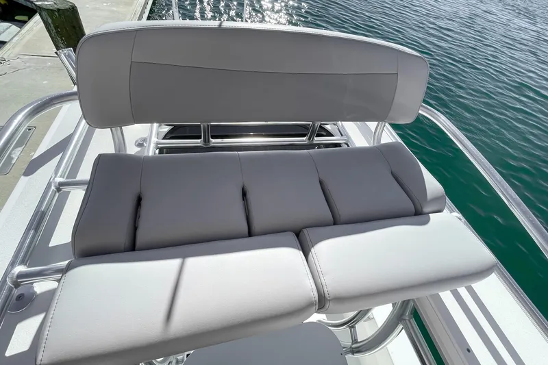 Slide: The Image of 2026 Bay Rider 269 Bay boat seat with sleek gray upholstery by the water. - 52
