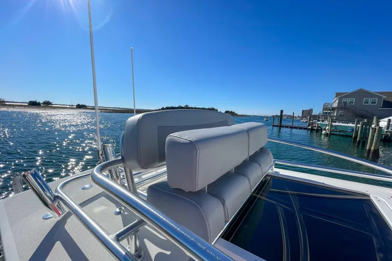 Slide: The Image of 2026 Bay Rider 269 Bay boat with sleek seating, docked under clear blue skies. - 58