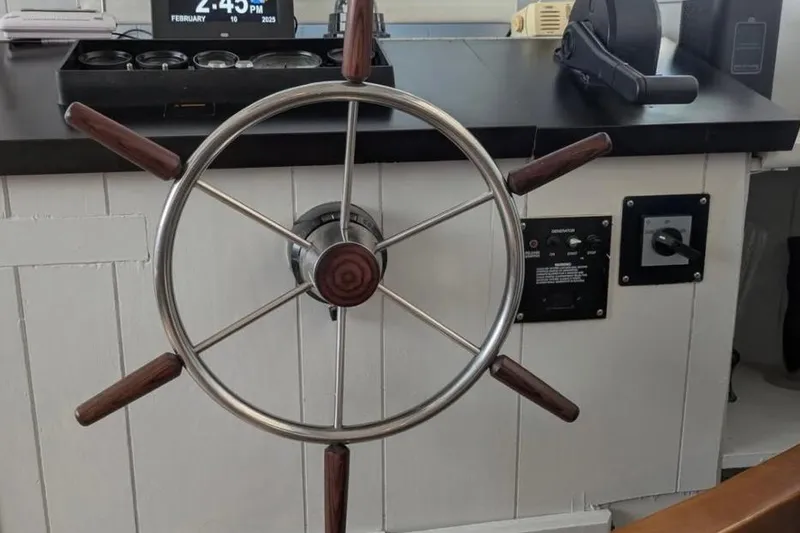 Slide: The Image of 1986 Stardust Cruisers houseboat helm with wooden steering wheel and control panel. - 15