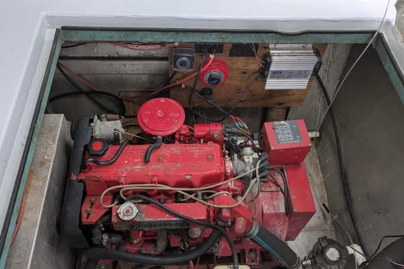 Slide: The Image of 1986 Stardust Cruisers houseboat engine compartment with red machinery and wiring. - 16
