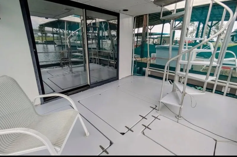 Slide: The Image of 1986 Stardust Cruisers houseboat interior with spiral staircase and sliding glass doors. - 3