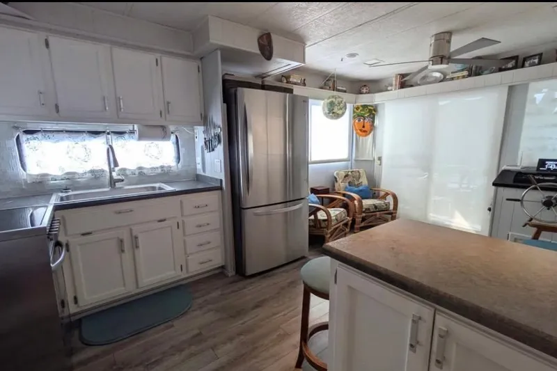 Slide: The Image of 1986 Stardust Cruisers houseboat kitchen with modern appliances and cozy seating area. - 5