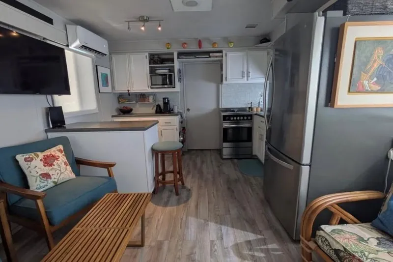 Slide: The Image of 1986 Stardust Cruisers houseboat interior with modern kitchen, seating, and decor. - 6