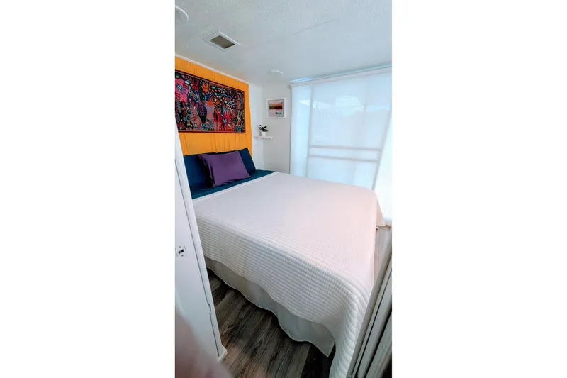 Slide: The Image of Cozy bedroom in 1986 Stardust Cruisers houseboat with colorful wall art and modern decor. - 9