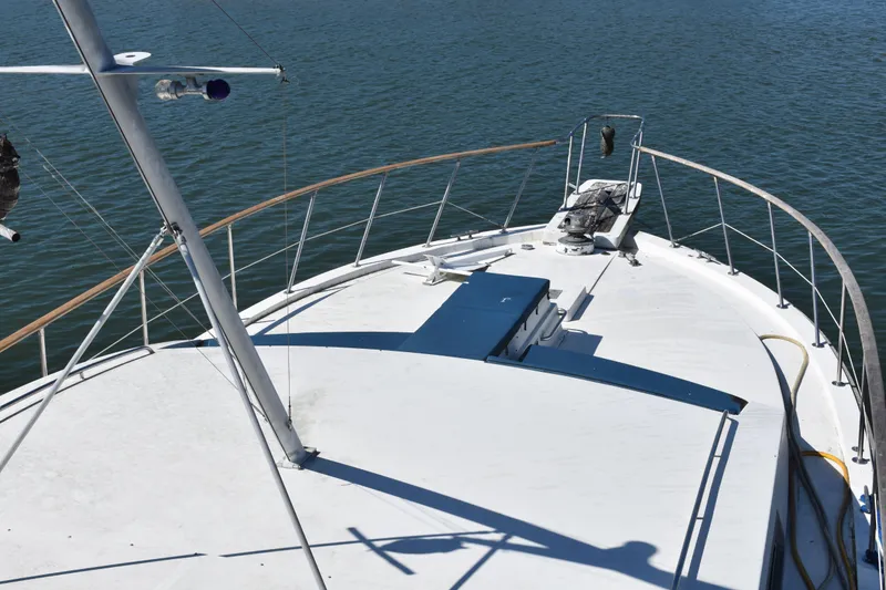 Slide: The Image of 1985 Bertram 58 Flybridge Motor Yacht bow view on calm water. - 15