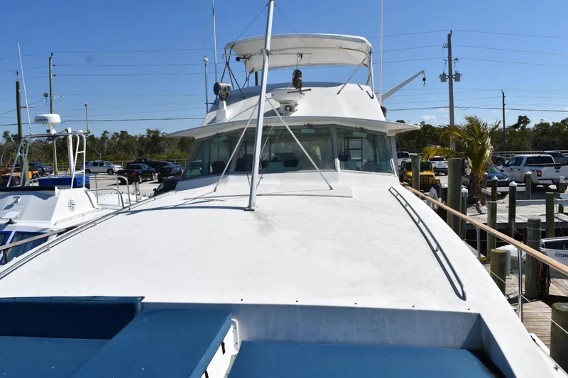 Slide: The Image of 1985 Bertram 58 Flybridge Motor Yacht docked at marina under clear blue sky. - 17