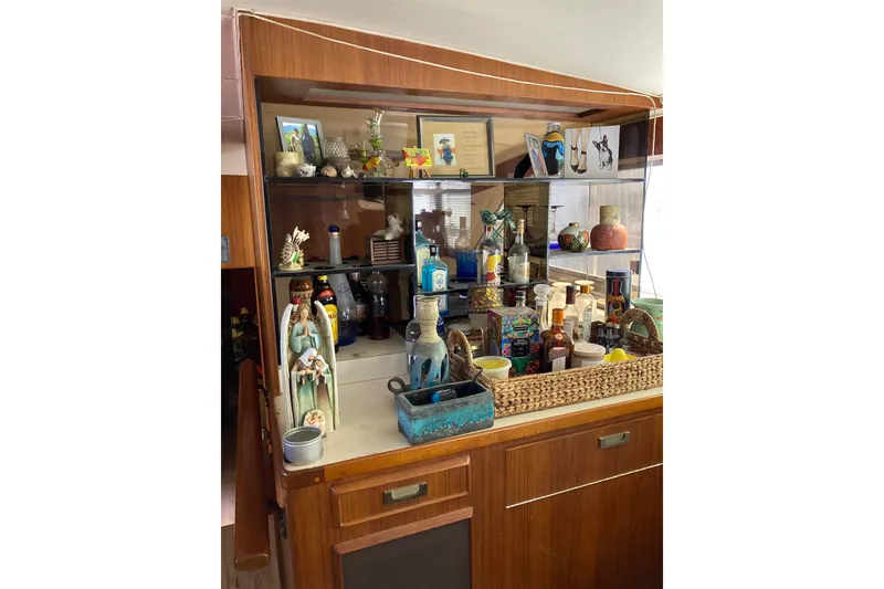 Slide: The Image of Interior of 1985 Bertram 58 Flybridge Motor Yacht with decorative items and bottles. - 21