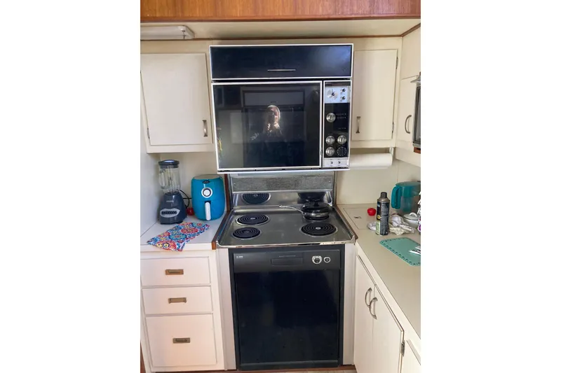 Slide: The Image of 1985 Bertram 58 Flybridge Motor Yacht kitchen with stove, oven, and appliances. - 25