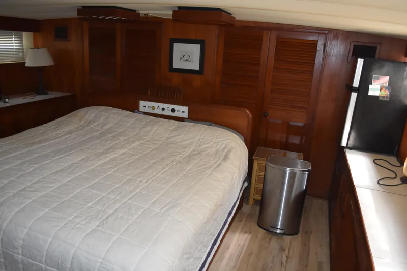Slide: The Image of 1985 Bertram 58 Flybridge Motor Yacht bedroom with wood paneling and cozy bed. - 38