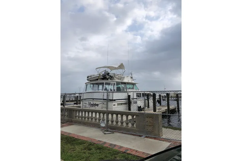 Slide: The Image of 1985 Bertram 58 Flybridge Motor Yacht docked under cloudy skies. - 7