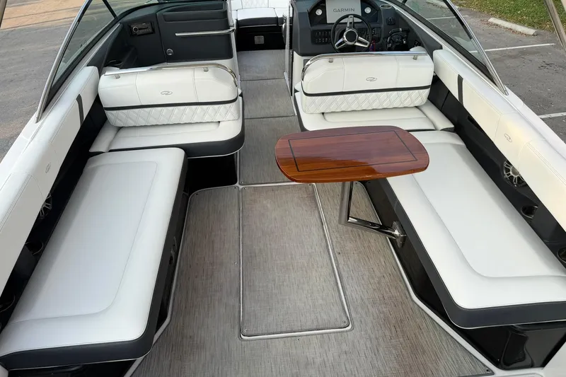 Slide: The Image of 2019 Regal 29 OBX boat interior with white seating and wooden table. - 19