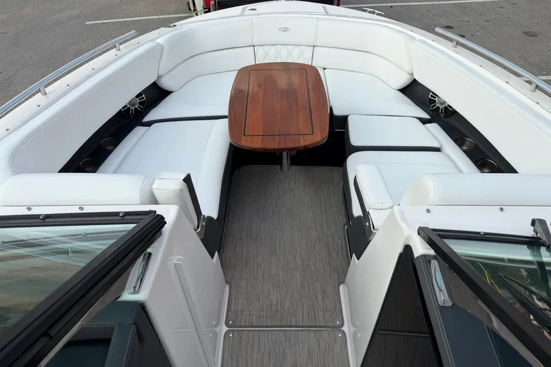 Slide: The Image of 2019 Regal 29 OBX boat interior with white seating and wooden table. - 27