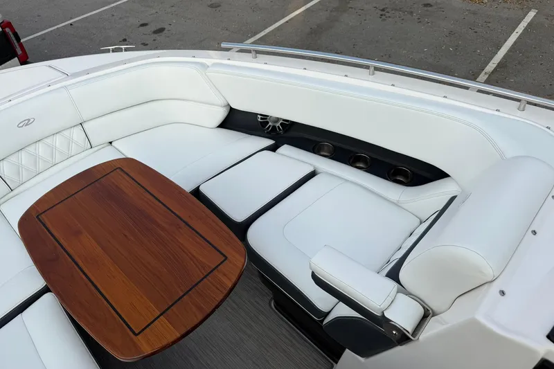 Slide: The Image of Luxurious seating area on a 2019 Regal 29 OBX boat with wooden table and white upholstery. - 28