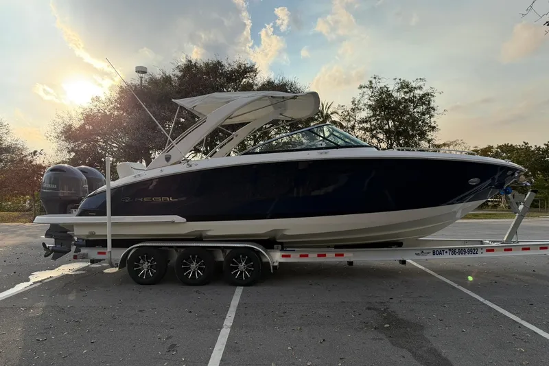 Slide: The Image of 2019 Regal 29 OBX boat on trailer at sunset, parked in a lot. - 3