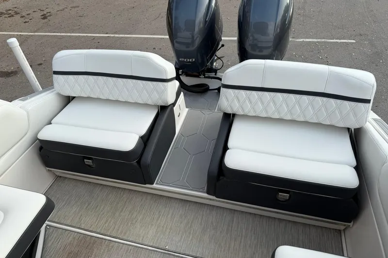Slide: The Image of 2019 Regal 29 OBX boat interior with white cushioned seating and dual outboard motors. - 34