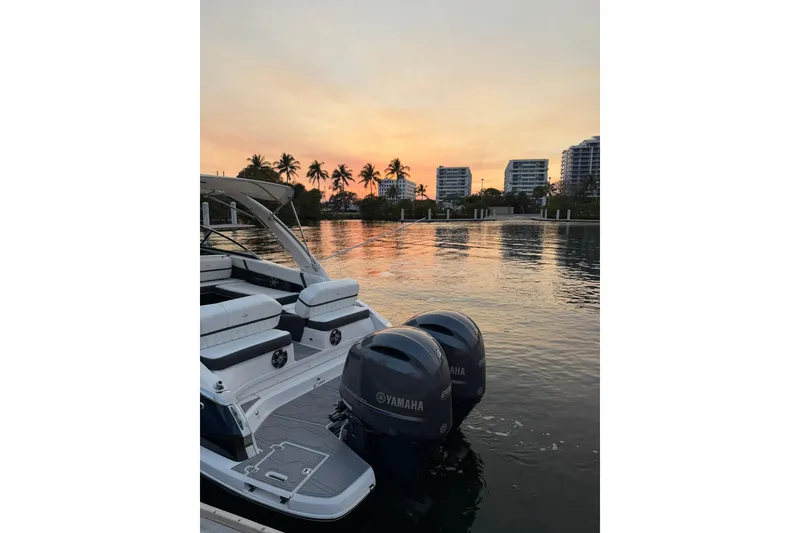 Slide: The Image of 2019 Regal 29 OBX boat with Yamaha engines at sunset, near waterfront buildings and palm trees. - 41