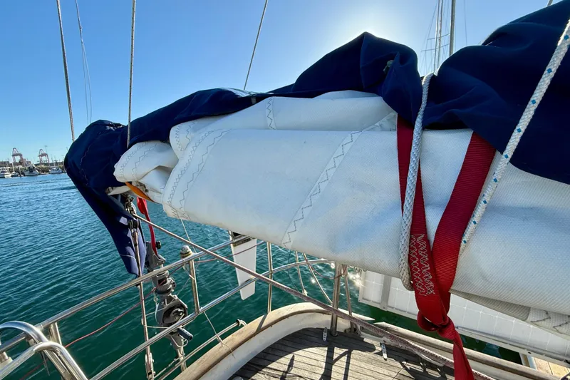 Slide: The Image of Sailboat deck view, Mariner Mayflower 1981, with sails and rigging against blue sky. - 16
