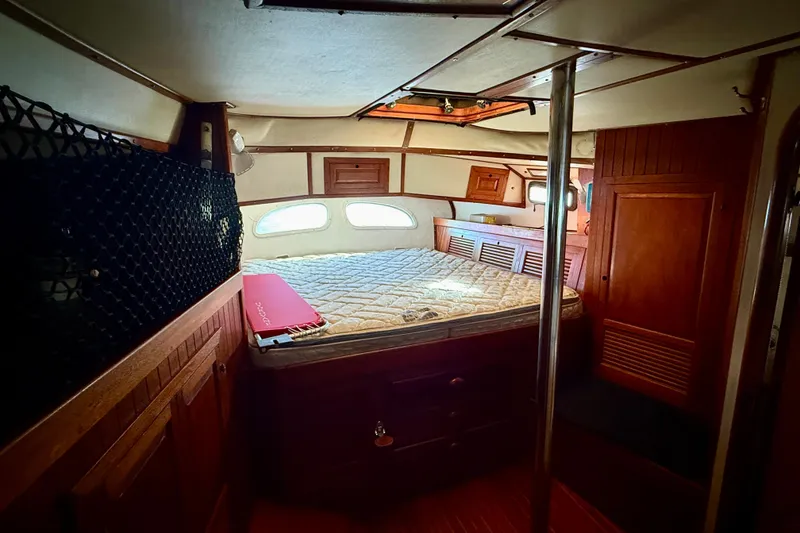 Slide: The Image of Cozy cabin interior of 1981 Mariner Mayflower yacht with wooden furnishings and a bed. - 27